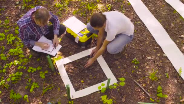 Dois ecologistas obtendo amostras de solo na floresta — Vídeo de Stock