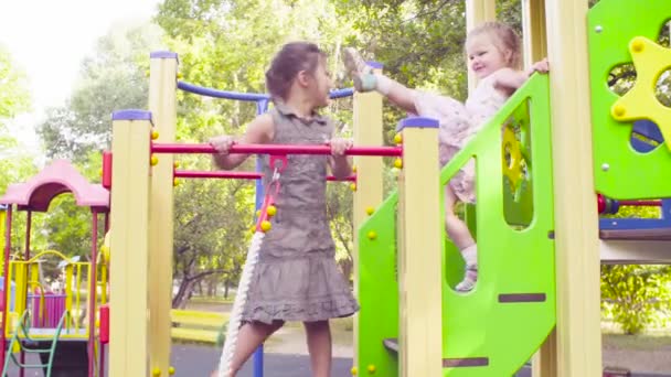 Drie meisjes op een complexe spelen op de speelplaats — Stockvideo