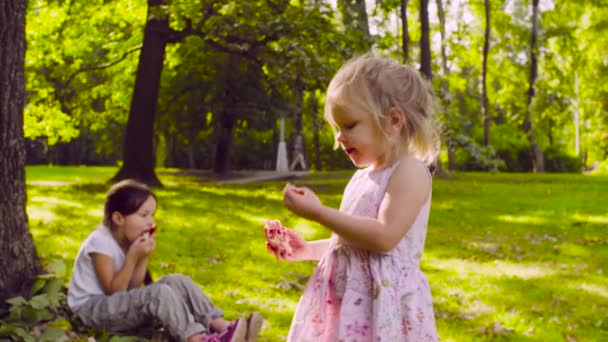 Deux filles dans le parc mangeant du grenat 