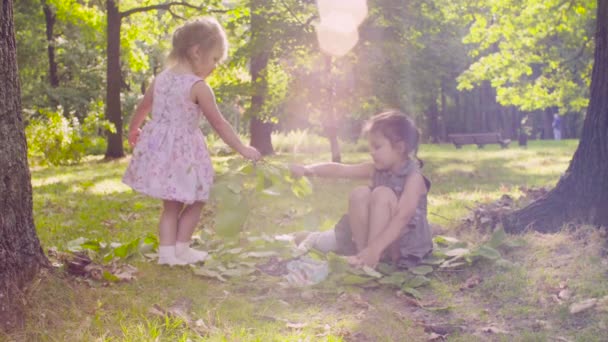 Deux filles jouant dans le parc sur l'herbe près de l'arbre 