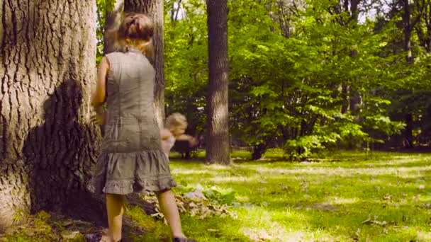 Deux filles jouant dans le parc sur l'herbe près de l'arbre 