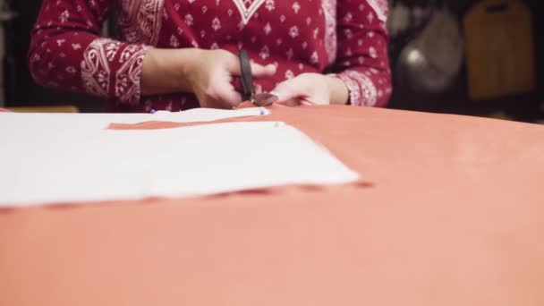 Middelbare leeftijd vrouw handen met schaar snijden stof — Stockvideo