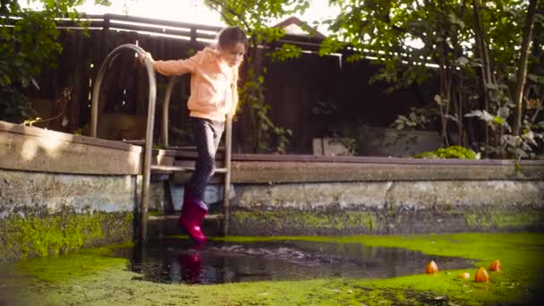 Dua gadis bermain di dekat kolam tua ditumbuhi rumput liar — Stok Video