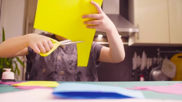 Little girl cutting colored paper with scissors — Stock Video