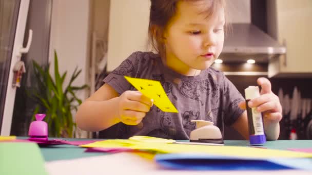 Meisje verlijmen gekleurd papier — Stockvideo