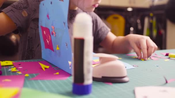 Kleines Mädchen klebt buntes Papier — Stockvideo