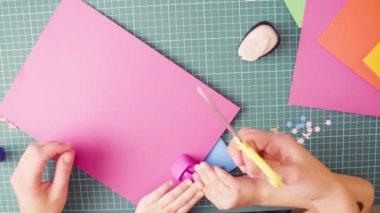 Üstten görünüm. Scrapbooking. Küçük kız kesme çiçek renkli kağıttan elleri. Çocuk yaratıcılık, el sanatları