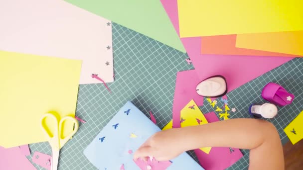 Manos de niña pegando papel de colores — Vídeos de Stock