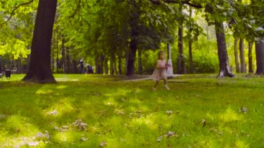 Disk uçan ile bir parkta oynayan küçük bir kız