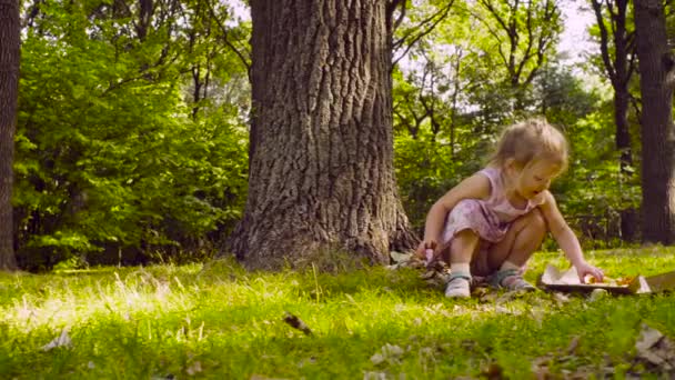 Petite fille assise dans le parc et mangeant de la pizza 