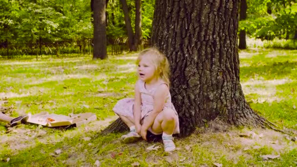 Tres chicas jugando en el parque en la hierba cerca del árbol — Vídeo de stock