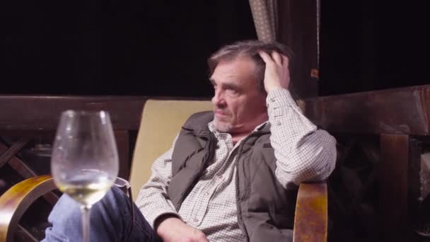 Homme âgé assis sur une chaise boire du vin et fumer — Video