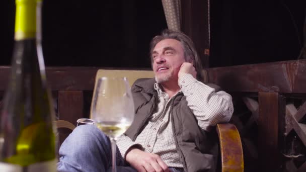 Homme âgé assis sur une chaise boire du vin et fumer — Video