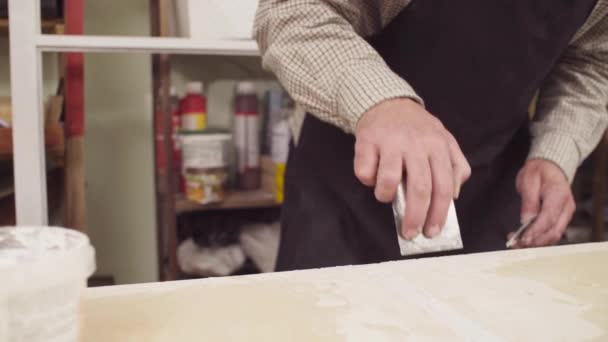 Händerna på ledande carpenter spackling träskiva — Stockvideo