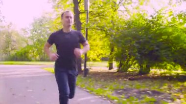 Parkta koşan genç adam. Fitness