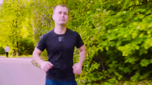 Νεαρός άνδρας τρέχει στο πάρκο. Γυμναστήριο — Αρχείο Βίντεο
