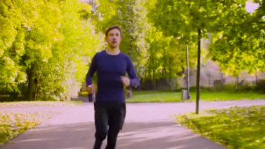 Parkta koşan genç adam. Fitness