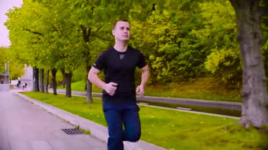 Parkta koşan genç adam. Sonbahar. Fitness