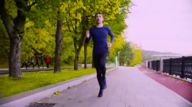 Parkta koşan genç adam. Sonbahar. Fitness