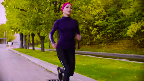 Una joven corriendo por el parque. Otoño. Aptitud — Vídeo de stock