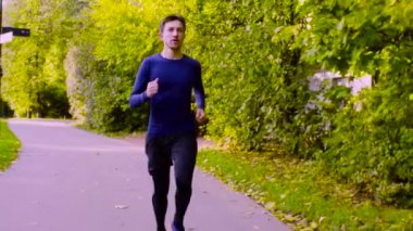 Parkta koşan genç adam. Fitness