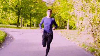 Parkta koşan genç adam. Fitness