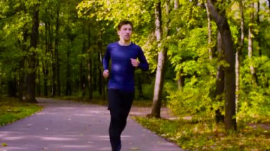 Parkta koşan genç adam. Fitness