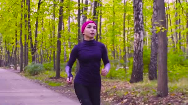 Νεαρή γυναίκα τρέχει στο πάρκο. Γυμναστήριο — Αρχείο Βίντεο