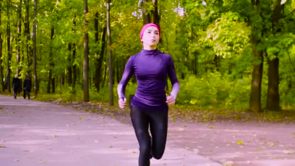 Junge Frau läuft durch den Park. Fitness — Stockvideo