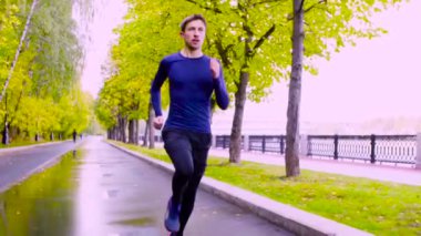 Parkta koşan genç adam. Sonbahar