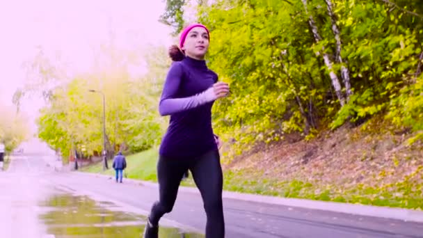 Νεαρή γυναίκα τρέχει στο πάρκο. Το φθινόπωρο — Αρχείο Βίντεο