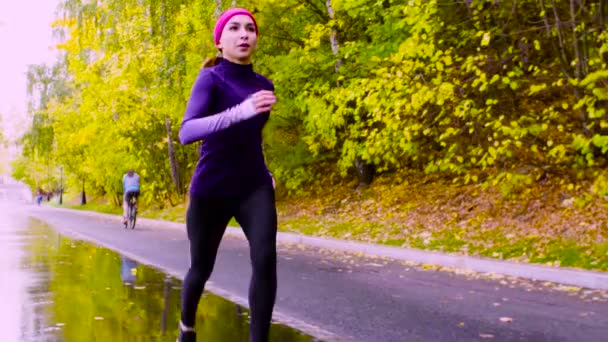 Junge Frau läuft durch den Park. Herbst — Stockvideo