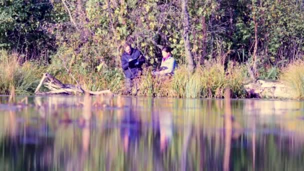 Dos científicos ecologistas en bosque salvaje en la orilla del río — Vídeo de stock