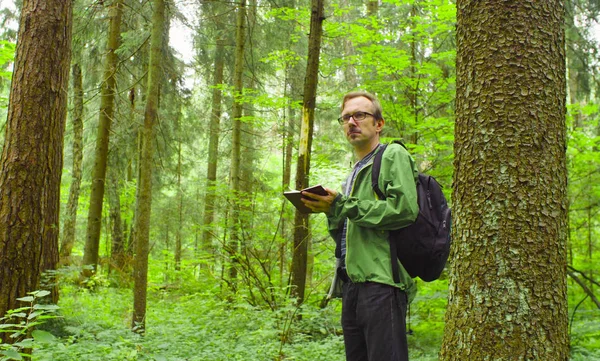 De ecoloog in een forest schrijven in notitieblok. — Stockfoto