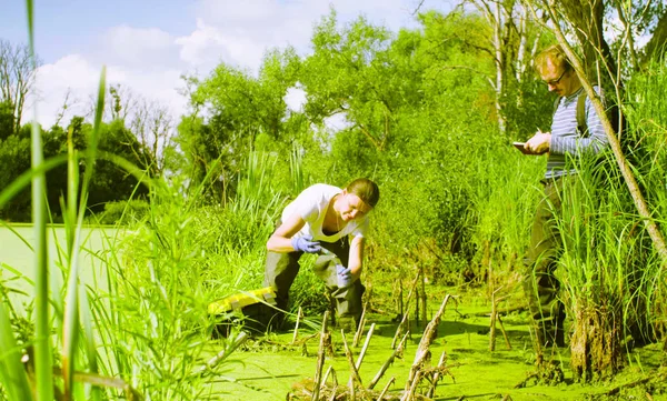 Vrouw ecoloog monsterneming van water en gieten het in de reageerbuis. — Stockfoto