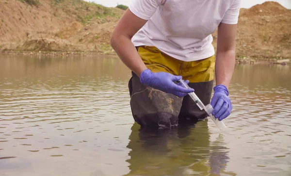 Mãos de mulher ecologista tirar amostras de água — Fotografia de Stock