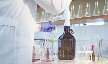 Kimyasal analiz laboratuvarı. Eller, bir bilim adamı titrating çözüm