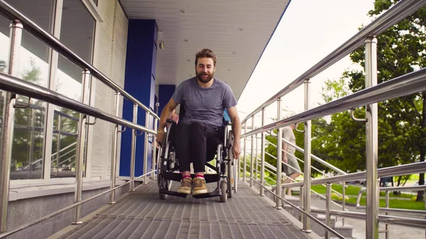 Людина з обмеженими можливостями в інвалідному візку їде по схилу — стокове фото