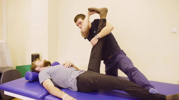 Arts doet stretching oefeningen voor ontredderen man — Stockfoto