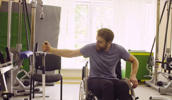 Postižený člověk vozíku dělá cvičení ruky — Stock fotografie
