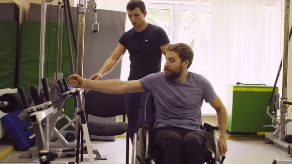 Postižený člověk vozíku dělá cvičení ruky — Stock fotografie