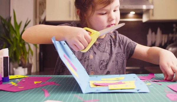 Meisje gekleurd papier snijden met schaar — Stockfoto