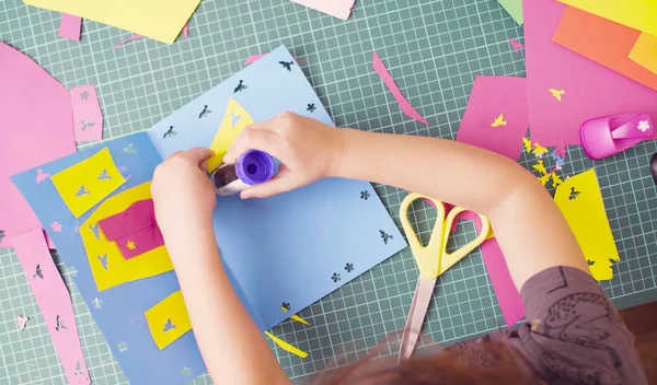 Handen van meisje lijmen van gekleurd papier — Stockfoto