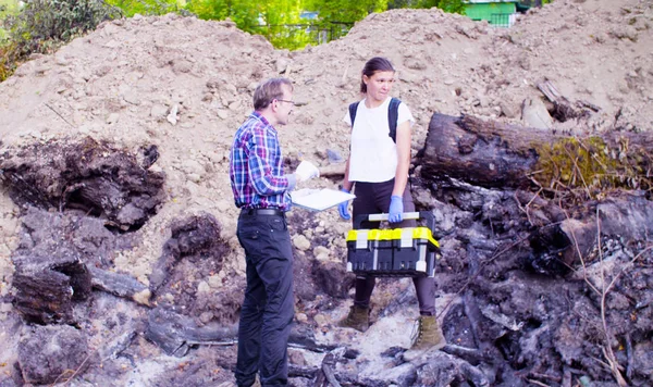 Два ученых эколога стоят на месте, где сгорел лес — стоковое фото