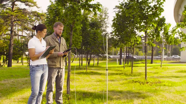 Two ecologist measuring the noise level near highway