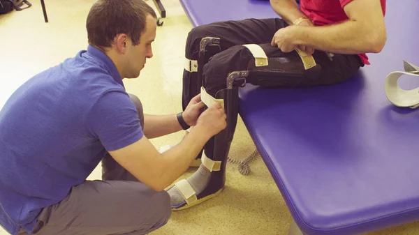 Elhelyezés a fogyatékos ember merevített orvos-gyógytornász — Stock Fotó