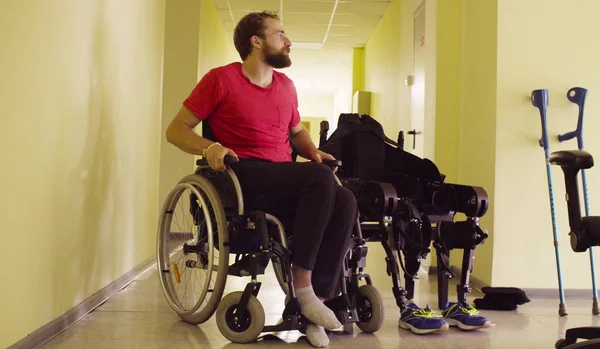 Вимкнути чоловіка, сидячи в інвалідному кріслі в реабілітаційній клініці — стокове фото
