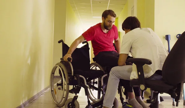 Mladá zakázat muž mění lavice na invalidní vozík — Stock fotografie