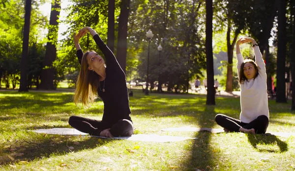 Jóga. Két csinálás jóga exersices a parkban, vonzó nő — Stock Fotó