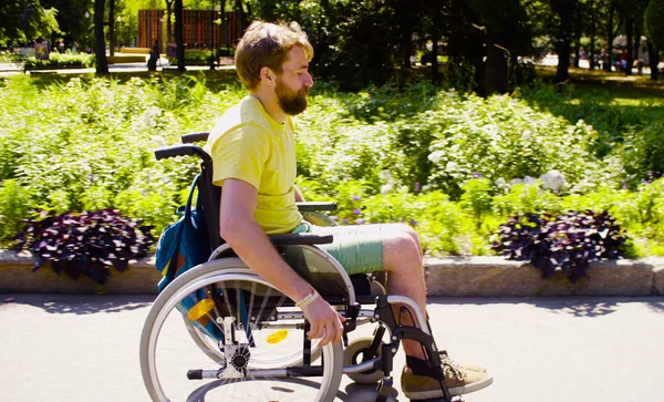 Joven hombre incapacitado en silla de ruedas en el parque —  Fotos de Stock